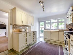 a kitchen with white cabinets and a large window at Greenacre in Fawkham