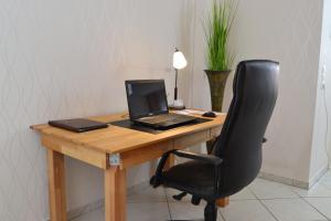 a desk with a laptop computer sitting on top of it at Ferienwohnung Zauber der Pfalz nahe Speyer in Römerberg