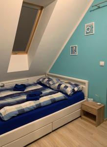 a bedroom with a bed with blue walls at Ferienhaus Lilja mit Garten und Pool in Trzęsacz