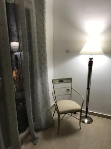 a chair in a room with a lamp and a curtain at Nefeli Β1 apartment in Thiva