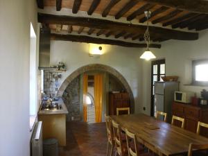 Il comprend une cuisine et une salle à manger avec une table en bois. dans l'établissement Villa Campo, à Chianni