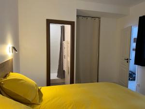 a bedroom with a yellow bed and a mirror at Le Landry Destination Val Cenis-Lanslevillard in Lanslevillard