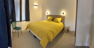 a bedroom with a yellow bed and a chair at Le Landry Destination Val Cenis-Lanslevillard in Lanslevillard