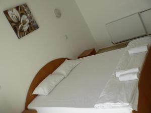 コスティネシュティにあるCasa Havanaの白いシーツと枕が備わる客室のベッド1台分です。