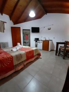 a bedroom with a large bed and a kitchen at Complejo Mi Viejo Vicente in Merlo