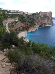 a beach on a cliff next to the ocean at la ventana al mar in Jávea