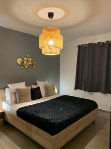 een slaapkamer met een bed en een kroonluchter bij La Maison de la Mer in Posada