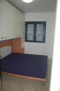 ヴァッレドーリアにあるValledoria 2 Apartmentsのベッドルーム(青いベッド1台、窓付)