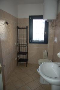 ヴァッレドーリアにあるValledoria 2 Apartmentsのバスルーム(トイレ、洗面台付)、窓が備わります。