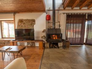 a living room with a fireplace and a table at Quinta Lourena - Casa do Desassossego in Covilhã