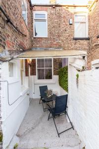 a patio with two chairs and a table in front of a building at York Deluxe Apartments in York