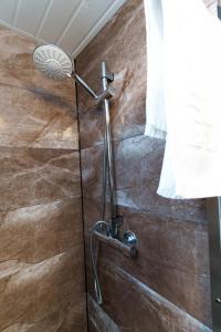 a shower with a shower head in a bathroom at York Deluxe Apartments in York