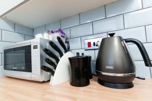 a kitchen counter with a coffee maker and a microwave at York Deluxe Apartments in York