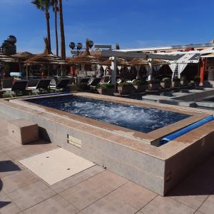 a swimming pool with chairs and umbrellas at a resort at Gîte Rural de Marrakech in Marrakech