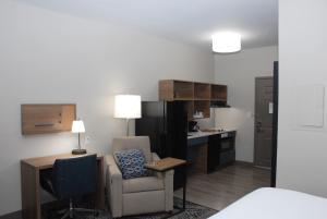 a room with a desk and a chair and a kitchen at Candlewood Suites Tallahassee, an IHG Hotel in Tallahassee