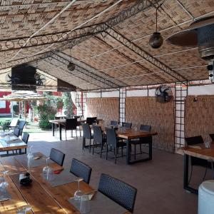 a restaurant with wooden tables and chairs and a large ceiling at Gîte Rural de Marrakech in Marrakech
