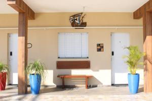 a room with two potted plants and a bench at Kitnet Maitinga in Bertioga