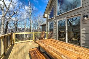 una terraza con un banco de madera en una casa en Designer Home with Fire Pit about 70 Steps to Slopes!, en Wintergreen