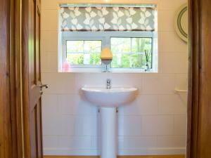 lavabo blanco en un baño con ventana en Dabinett, en Ledbury