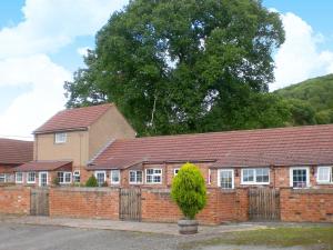 a brick house with a tree in front of it at Dabinett in Ledbury