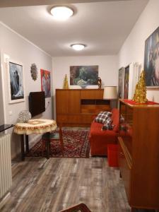 sala de estar con sofá rojo y mesa en AppartamentoMonika con parcheggio privato - Volano, en Volano