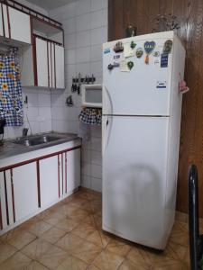 cocina con nevera blanca y fregadero en Casa ana en Ezeiza