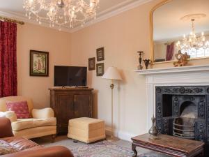 a living room with a fireplace and a mirror at 1 Severn Bank in Ironbridge