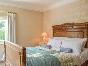 a bedroom with a large bed with a wooden headboard at 1 Severn Bank in Ironbridge