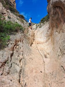 a person walking down a dirt hillside with a person standing on it at la ventana al mar in Jávea
