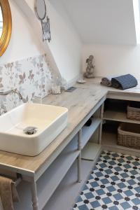 La salle de bains est pourvue d'un lavabo sur un comptoir en bois. dans l'établissement La Maison de Sylvie, chambres d'hôtes à Tarbes, à Tarbes