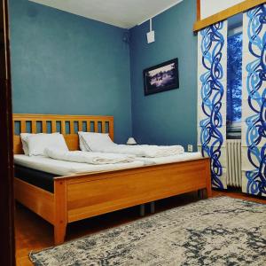 a bed in a room with a blue wall at Nederhögen Vildmarkscenter in Rätan