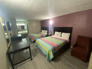 una habitación de hotel con 2 camas y una silla en DIAMOND INN, en Forrest City