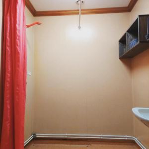 a bathroom with a red curtain and a sink at Nederhögen Vildmarkscenter in Rätan