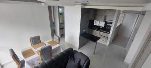 a living room with a couch and a kitchen at HERMOSO APARTAMENTO CON BALCON, 3 Alcobas, 2 baños in Cartagena de Indias