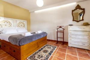 a bedroom with a bed with a dresser and a mirror at Casa do Corticeiro in Arraiolos