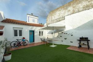 a bike is parked on a patio with an umbrella at Casa do Corticeiro in Arraiolos