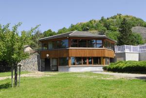a large house with glass windows on a hill at VVF Haute Loire Saint-Julien-Chapteuil in Saint-Julien-Chapteuil