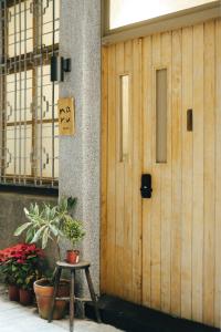 una puerta de madera de un edificio con un cartel en Maru en Tainan