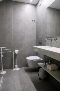 a bathroom with a sink and a toilet and a mirror at Canto dos Poetas in Leiria