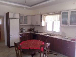 a kitchen with a table with a red table cloth at Traditional Apartment Up to 6 People - ΠΑΡΑΔΟΣΙΑΚΗ ΜΟΝΟΚΑΤΟΙΚΙΑ 6 ΑΤΟΜΩΝ 