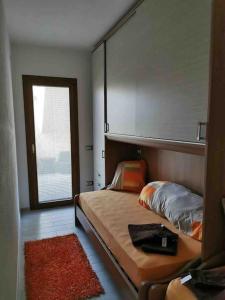 una piccola camera con letto e finestra di Apartment - Il Paradiso - where dreams come true a Valledoria