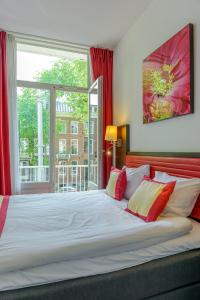 a bedroom with a large bed with a large window at Hotel Allure in Amsterdam