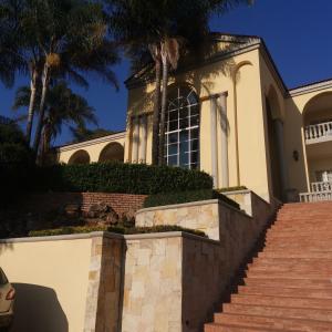 a house with palm trees and stairs in front of it at TDM's Boutique Guest House in Pretoria