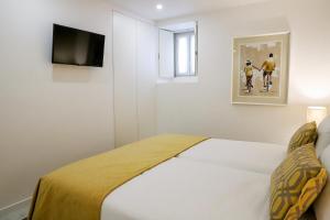 a bedroom with a bed and a tv on a wall at Canto dos Poetas in Leiria