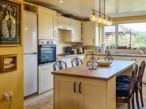 a kitchen with white appliances and a large island at Whiteadder Cottage in Spittal