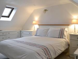 1 dormitorio con 1 cama blanca grande y 2 lámparas en Jebel, en Cullen