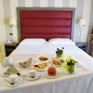 a table with a tray of food on a bed at Grand Hotel Elite in Cascia