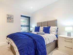 a bedroom with a blue bed and a window at Uk40240-the Bluebell in Scalby