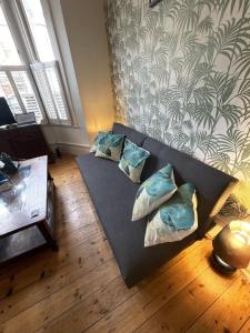 ロンドンにあるBeautiful ground floor garden flatのリビングルーム(枕付きの黒いソファ付)