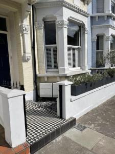 倫敦的住宿－Beautiful ground floor garden flat，前面有长凳的房子